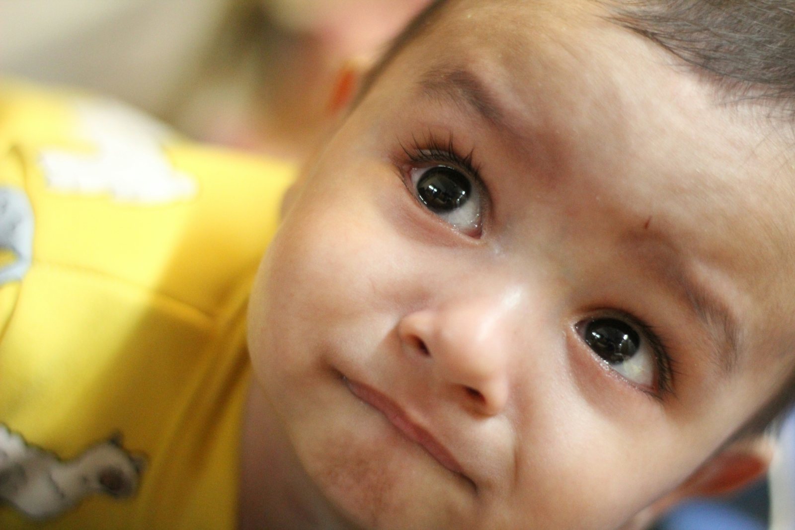 Kleines Kind schaut mit großen, wachen Augen nach oben